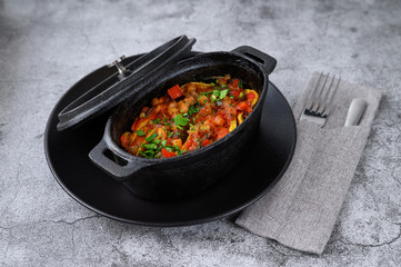 thinly sliced meat with sauce in a hot cast-iron pot