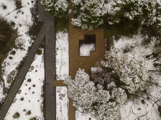 Flying over prak in the early spring. The snow is melting and the grass is green among the paths. Aerial drone view. 