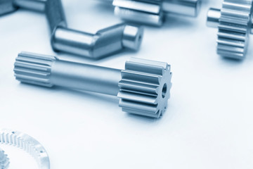 The close-up scene of various type of  the pinion gear parts shaft  in the light blue scene. The transmission gear parts manufacturing process concept for automotive industrial .