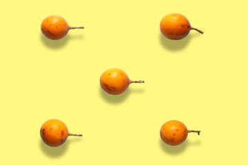 Colorful fruit pattern of granadilla or grenadia passion fruit on yellow background from top view
