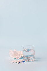 Vaccines Covid-19 Antivirus Corona virus. Glass of water and set of piil on blue background, minimal concept of antivirus pharmacy, Prevention of the spread of virus and pandemic