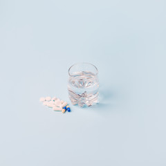 Vaccines Covid-19 Antivirus Corona virus. Glass of water and set of piil on blue background, minimal concept of antivirus pharmacy, Prevention of the spread of virus and pandemic