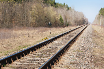 Railway with road signs through the forest