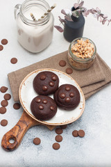 Chocolate chip cookies with glass of milk on gray background