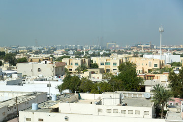 Old areas of the modern eastern metropolis. The small old houses and buildings of Dubai against the backdrop of new high-rise buildings.