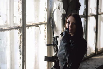 Concept of special agent girl with airsoft rifle is talking on radio station..