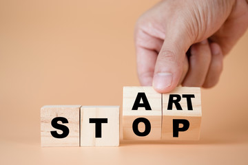 Hand flipping wooden cubes for change wording from stop to start.