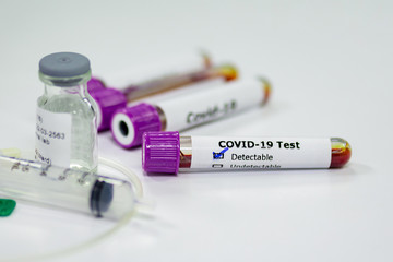 Blood sample tube of coronavirus or covid-19 disease with vaccine testing syringe. Medical and microbiologist science concepth photo.