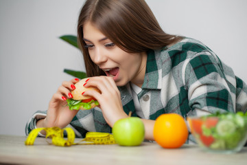 Cute woman makes a choice between healthy and harmful food