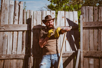 Cowboy portrait. Portrait of man while working in garden. Farmer on farmland. Planting concept. Farmer harvesting fresh vegetables from the garden and planning harvest.