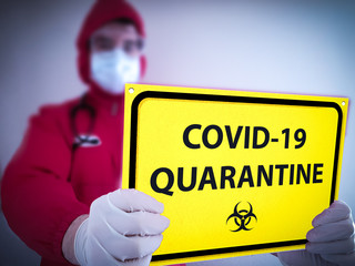 Corona virus Covid 19 Quarantine aler sign yellow. Doctor in isolation holds biohazard sign for...