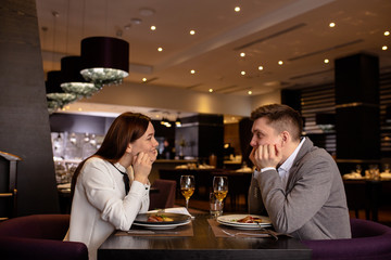caucasian couple in love, man and woman on a date in restaurant. happy beautiful couple look at each other and smile. love, relationships concept