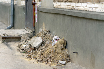 a pile of construction debris at the entrance door of the staircase next to the gas pipe