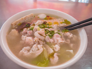 Close up Chinese Noodle top up with pork meat and vegetables in the soup in chinese Street food restaurant at china