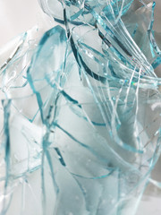 Glass transparent bottle on a white gray background broken into many fragments. Blue is a lot of fragments from under gaziorovki. Glass transparent containers, recycled materials, eco-friendly waste