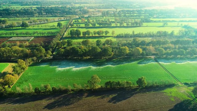 Frost Visible in the Shadow of a Row of Trees, Protected from the Sunshine, on a Green Field, Zooming In Shot &ndash; Friesland, Netherlands / Holland &ndash; 4K Drone Footage