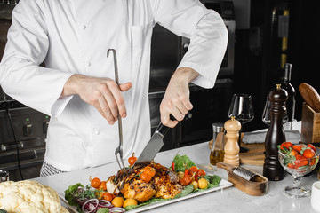 cropped professional cook cut cooked meat for restaurant visitors, chef-cooker beautifully decorates a plate in kitchen. culinary, gourmet concept