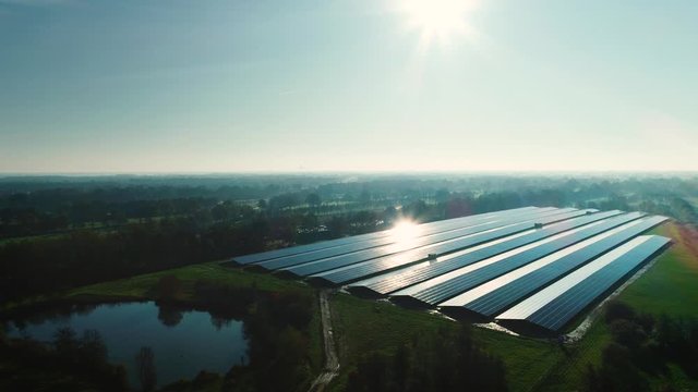 Solar Plant: Rows of Solar Panels Producing Sustainable Energy, Dark with Reflection From the Sun, Moving Right - Friesland, Netherlands / Holland &ndash; 4K Drone Footage