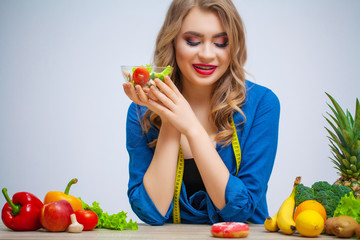 Cute woman makes a choice between healthy and harmful food