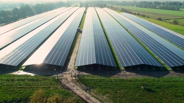 Solar Plant: Rows of Solar Panels Producing Sustainable Energy, Dark with Reflection From the Sun, Moving Sideways - Friesland, Netherlands / Holland &ndash; 4K Drone Footage