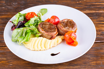 Beef medallions wrapped in bacon, served with puree and vegetables