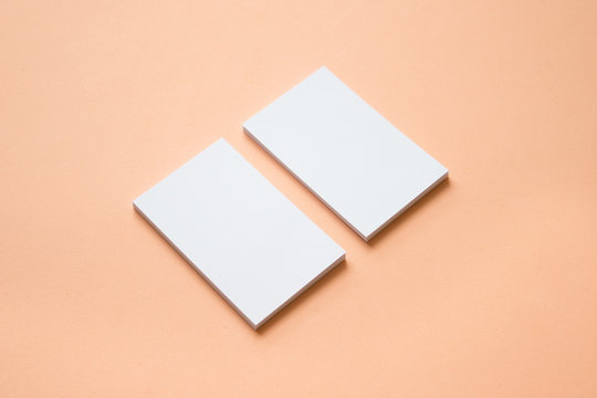 Mockup de tarjetas de visita blancas y horizontales sobre  fondo color salmón, coloca tu diseño aquí