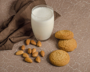 Almond milk shake in a glass on a beige background with oatmeal cookies. The concept of veganism, raw food diet