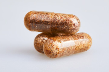 Transparent gelatin capsules with zink powder on white background. Pharmaceutical concept.