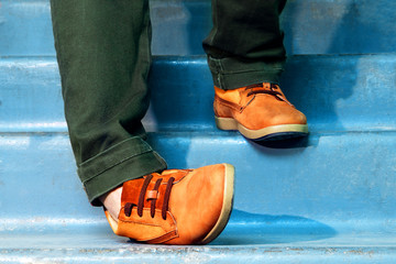 Close up portrait of legs with sneakers walking down stairs and spraining or dislocating ankle. - obrazy, fototapety, plakaty