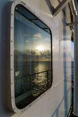 Sunrise reflection on a cabin galss window of a construction work barge at oil field