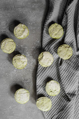 Large group of healthy avocado and spinach coconut bites lactose and gluten free on painted grey background with green napkin