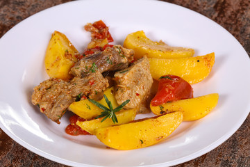 Baked pork meat with potao and tomato