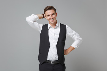 Funny young business man in classic black waistcoat shirt posing isolated on grey wall background...