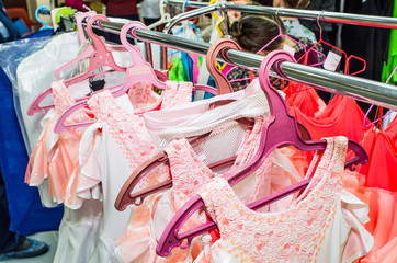 A row of stage costumes for upcoming performances by dance actors hangs on a floor hanger.