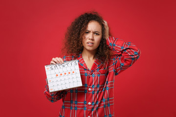 Tired african american girl in pajamas homewear rest at home isolated on red background. Relax good...