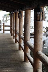 Naklejka premium log pole railing with hanging lanterns leading outside to log pole fencing in snowy scene