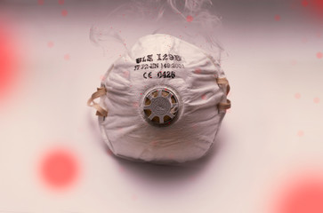 Mask infected with a virus such as coronavirus. Mask shrouded in smoke