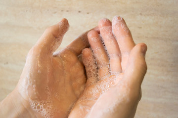 caucasian teenager washing hands on beige background