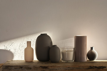 Vases against rough plaster wall at sunlight
