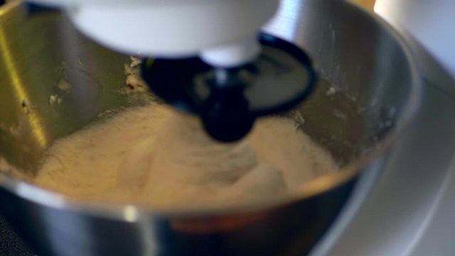 Mixing the gluten free dough with the help of a kitchen assistent. Close-up, no camera movements, filmed in slow motion at 1080p.