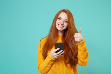 Smiling young redhead woman girl in yellow sweater posing isolated on blue turquoise background...