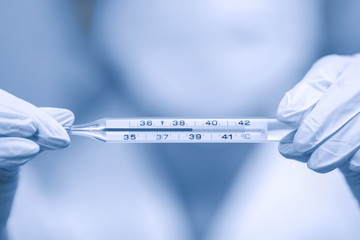 Nurse with thermometer in his hands.