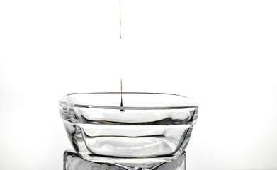 drop of chocolate falling into clear dish