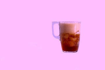 a mug is poured into it. Added ice cubes. Close-up. On a pink background.