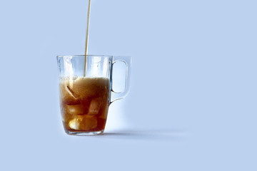a mug is poured into it. Added ice cubes. Close-up. Deign on a white background