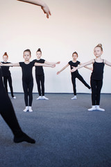 Fototapeta na wymiar Coach teaches girls to dance on lesson.