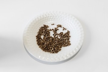buckwheat on a white saucer, isolate