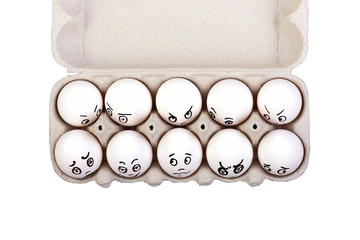 Eggs with different faces in a box isolated on white background.