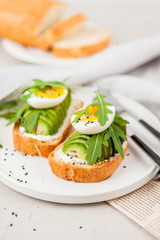 Toast with avocado, arugula and egg. Healthy Breakfast.