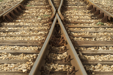 Intersection of railroad tracks covered with bonded stones with wooden sleepers.